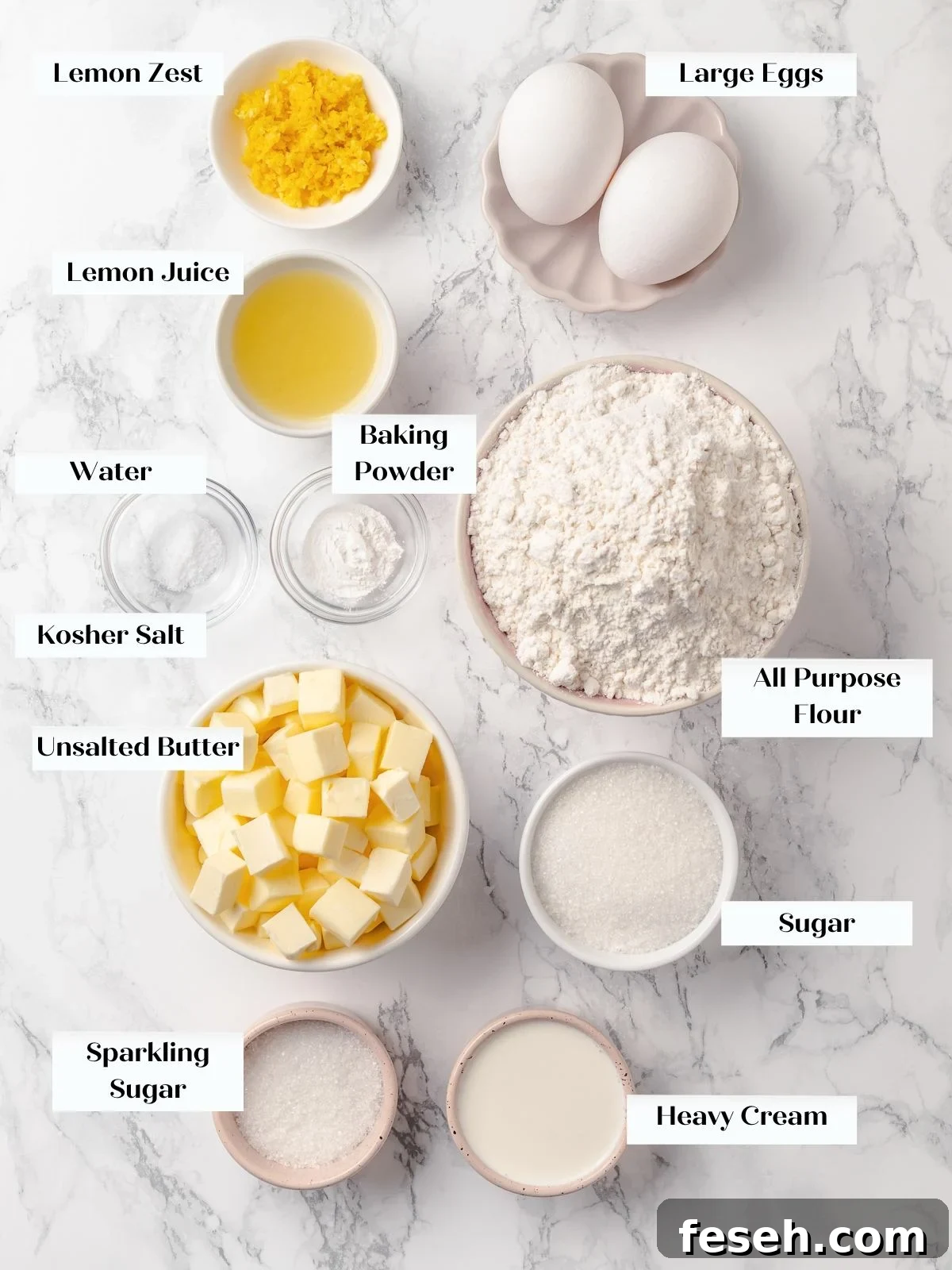 Ingredients for lemon scones arranged on countertop including flour, butter, eggs, and lemons.