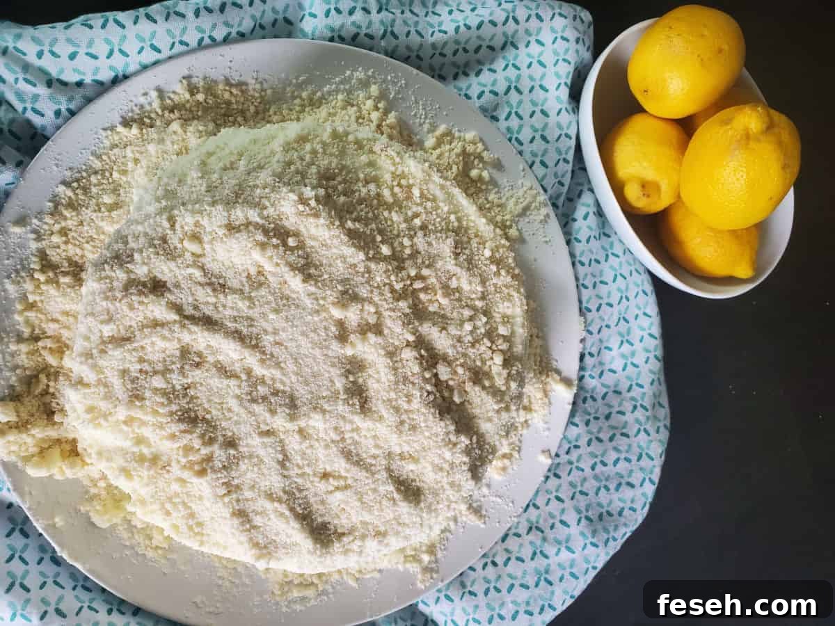 Looking down on a lemon cream cake next to a bowl of lemons