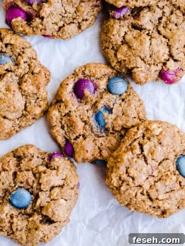 Freshly baked monster cookies on top of a piece of crinkled white parchment paper.