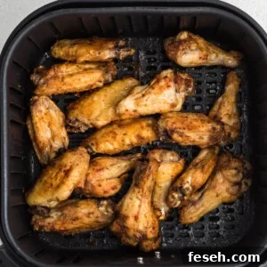 Chicken wings in the air fryer basket.