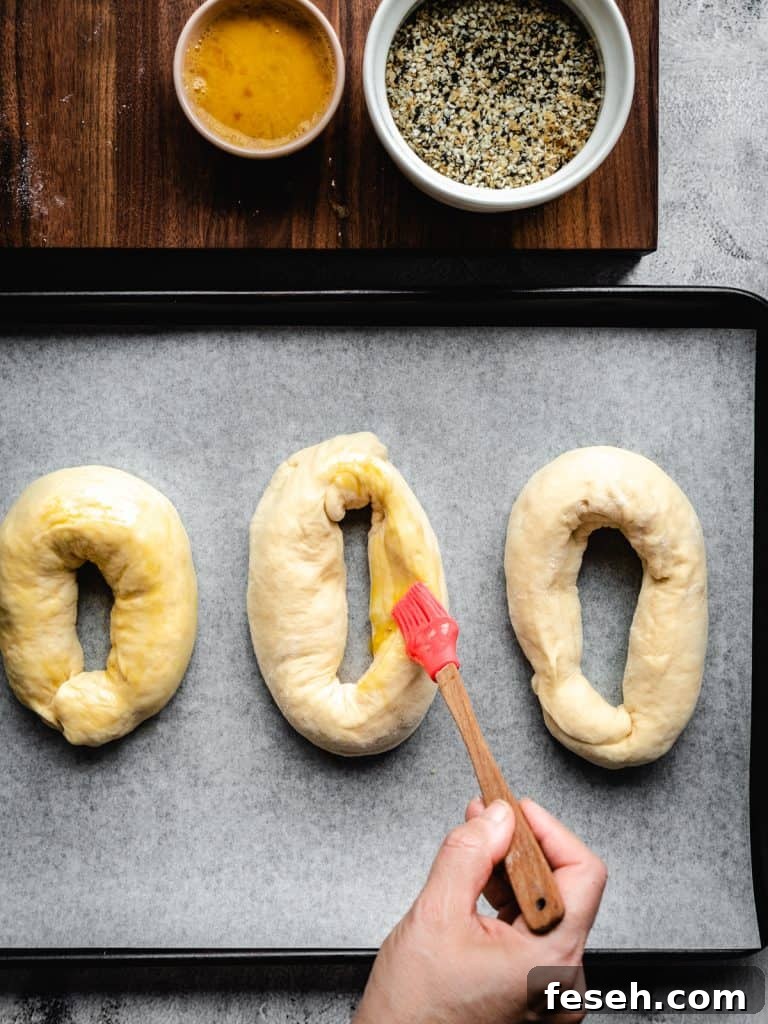 brushing egg wash on homemade bagels