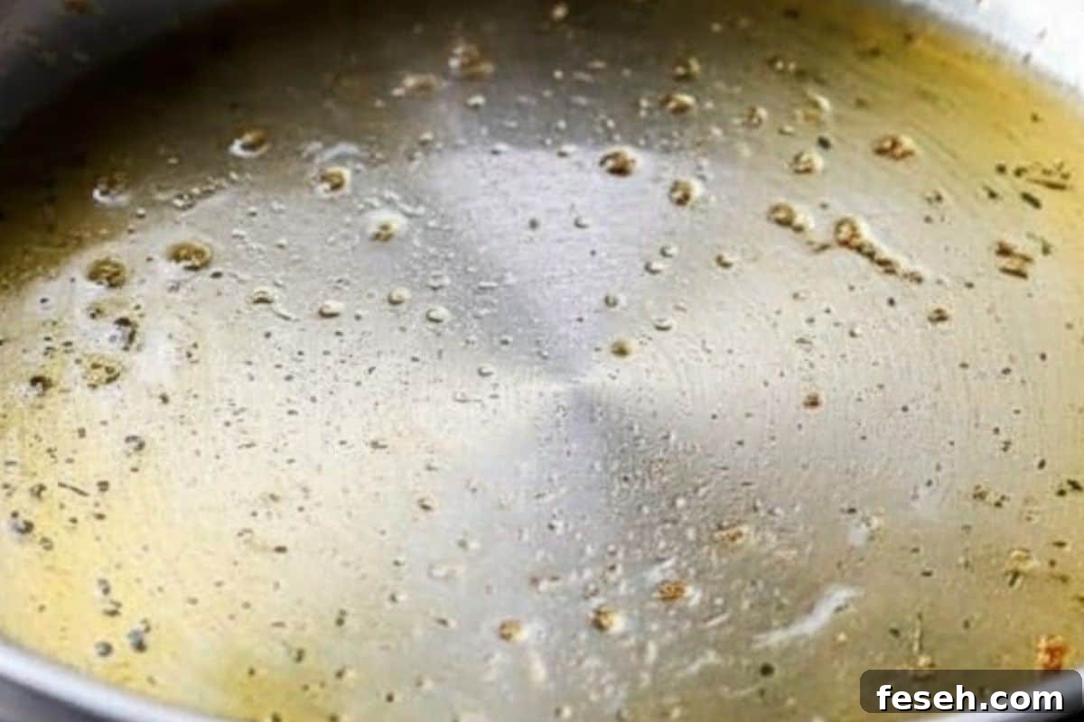 Drizzle the garlic olive oil into a large frying pan or skillet and place it over medium-high heat.