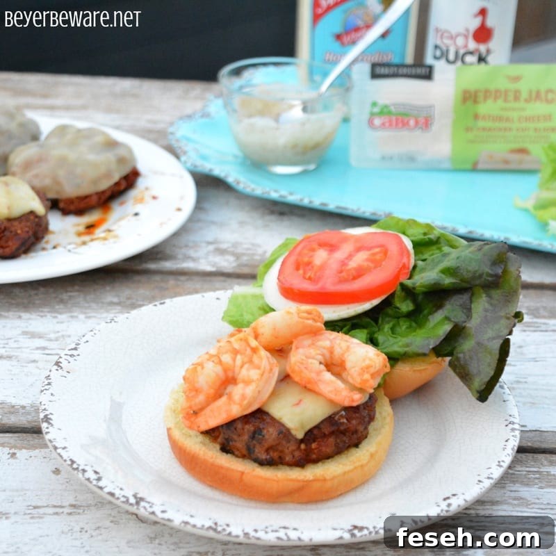 Cajun pork burger topped with shrimp and cheese