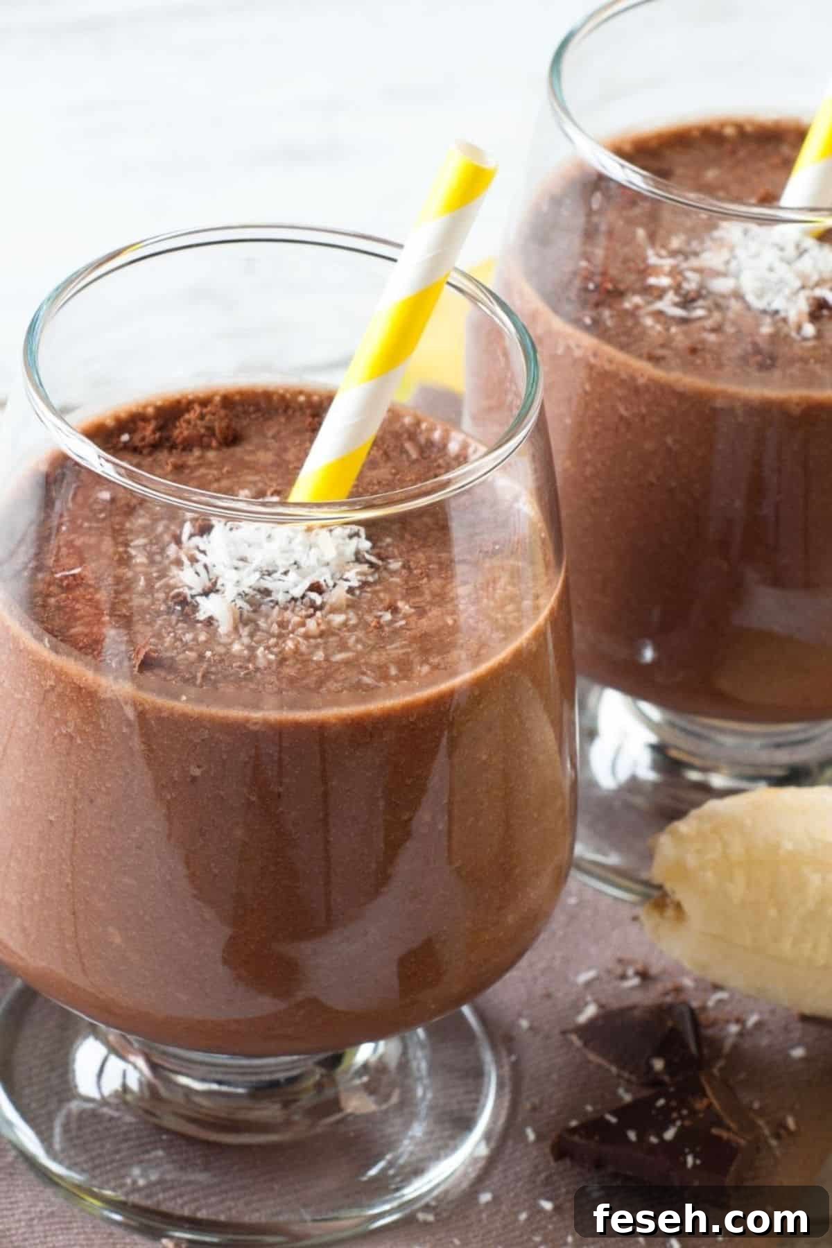 Chocolate Peanut Butter Banana Smoothie Recipe for Creamy Energy 3 Two glasses with yellow-striped straws, topped with shredded coconut.