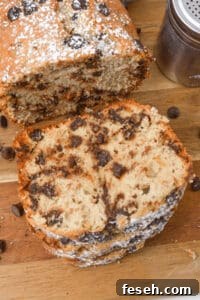 Chocolate Peanut Butter Banana Smoothie Recipe for Creamy Energy 7 A sliced loaf of chocolate chip banana bread rests on a wooden board, lightly dusted with powdered sugar.