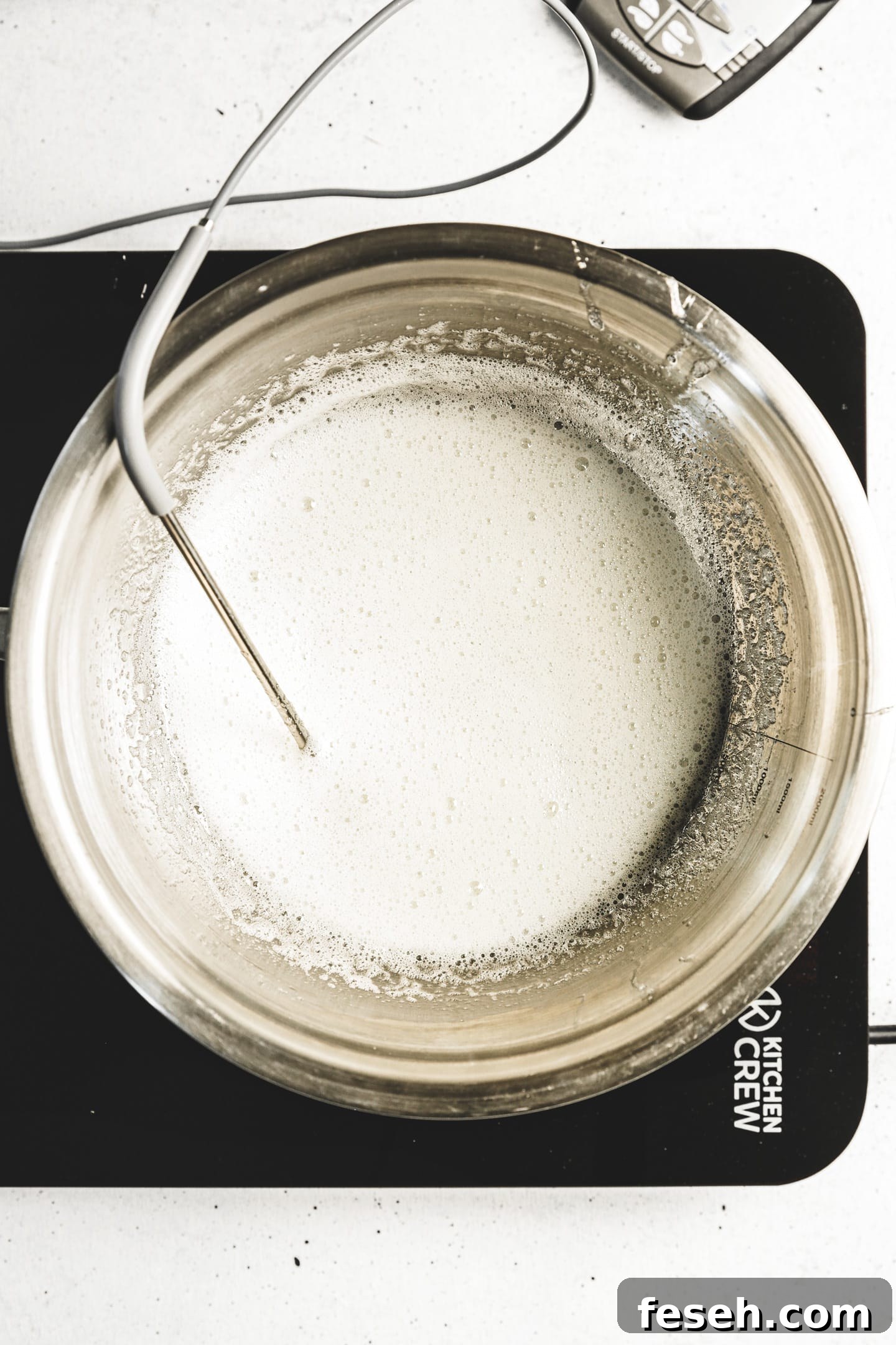 bowl with egg whites sugar and cooking thermometer