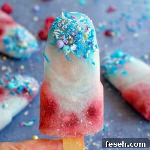blue raspberry popsicle being held up with more in the background