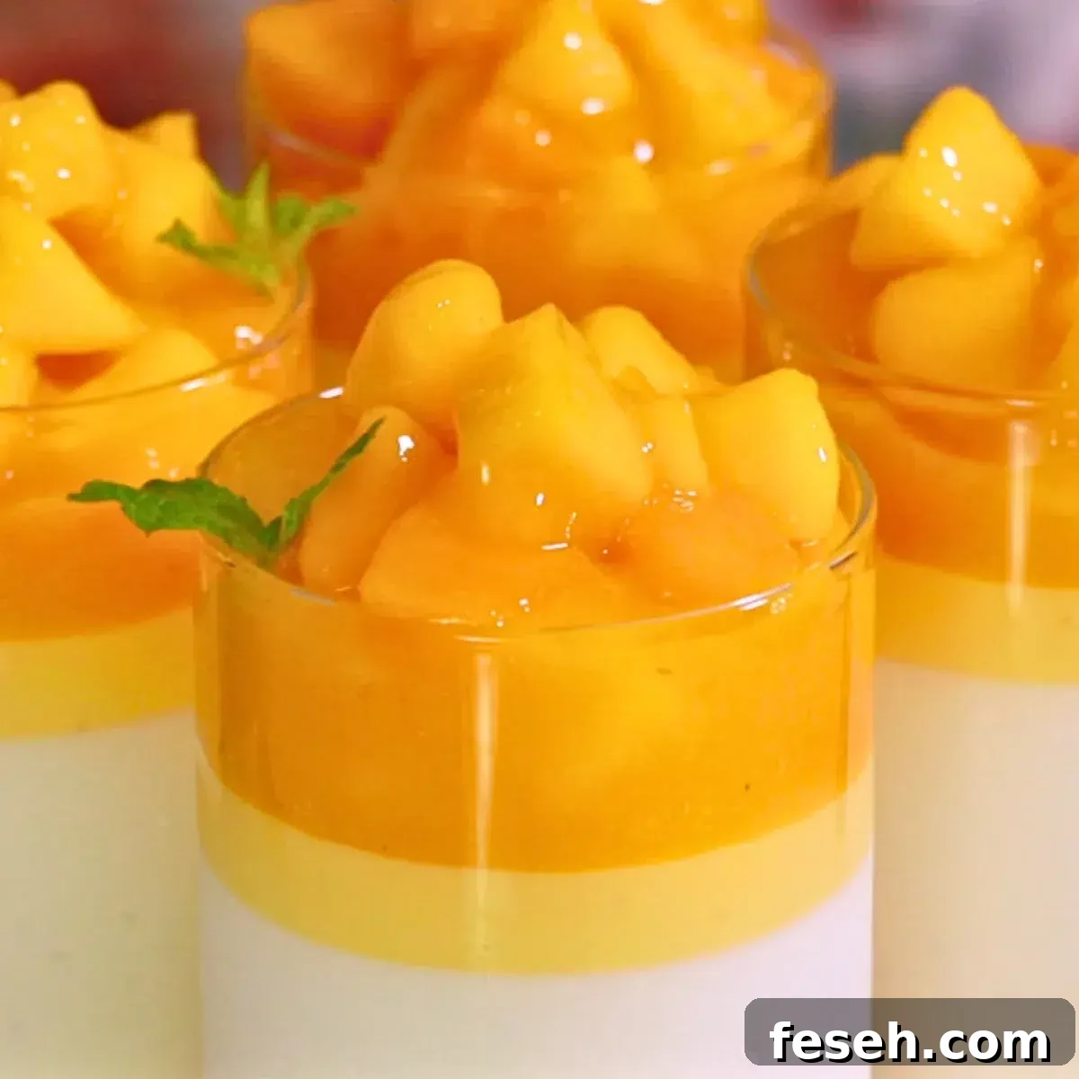 layers of vanilla and mango panna cotta with melty mango topping in glasses