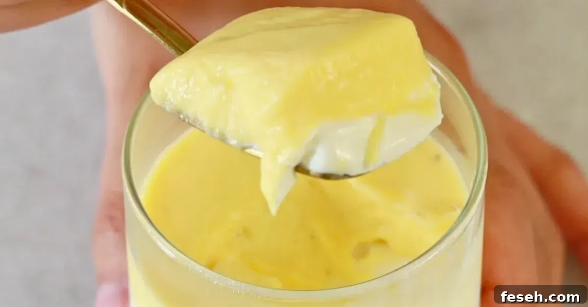 layers of vanilla and mango panna cotta in a spoon