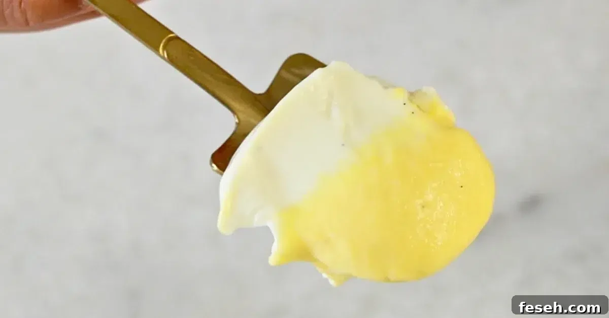 layers of vanilla panna cotta and mango panna cotta in a spoon