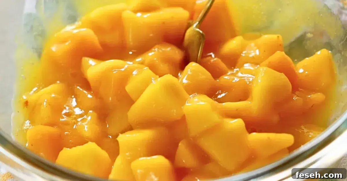 mixing fresh mango and pureed mango in a bowl