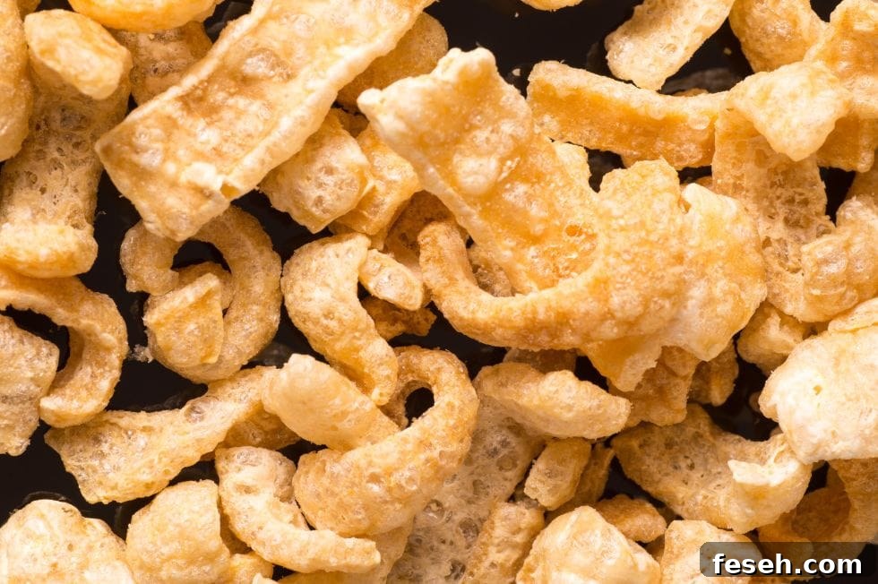 closeup of crunchy keto snacks pork rinds on a black background