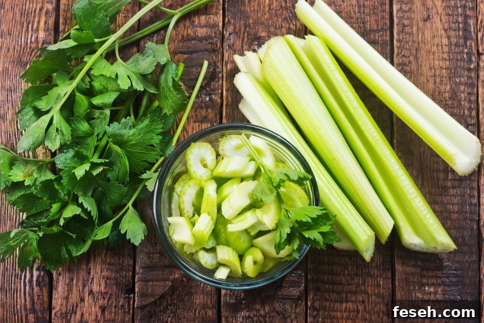 beautiful display of crunchy keto snacks fresh celery on a cutting board next to a bowl of cut celery