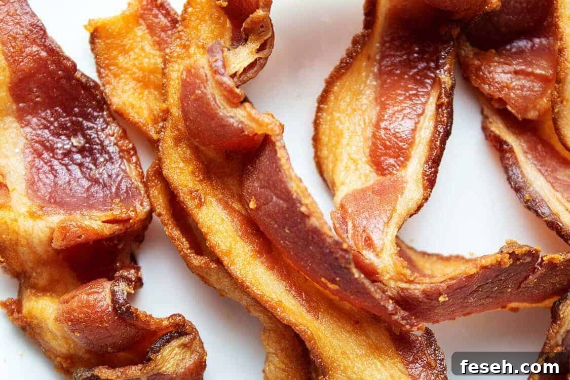 closeup of several slices of air fryer bacon on a white plate