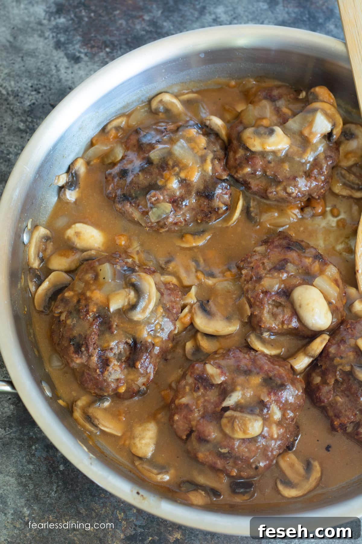 A pan full of cooked Salisbury Steak.