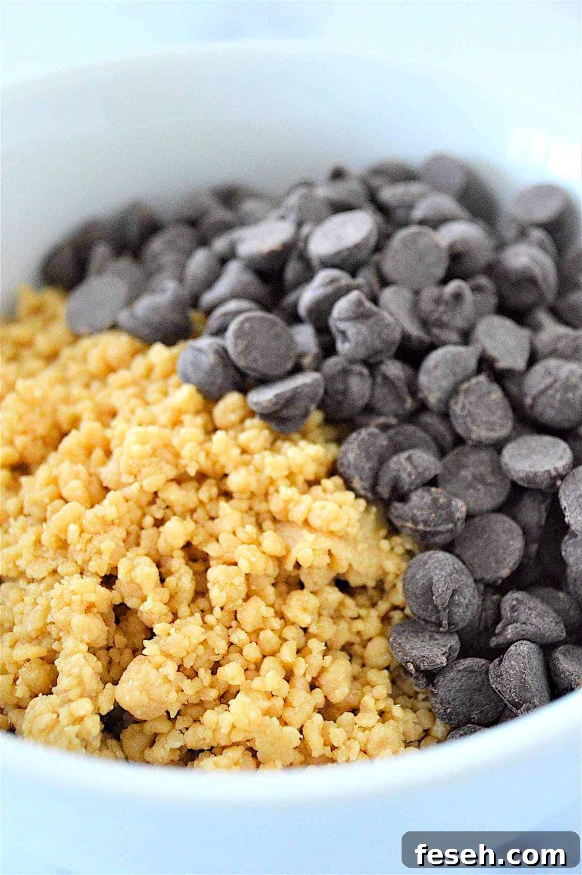 A process image showing how to mix chocolate chips into no bake energy ball dough in a bowl.