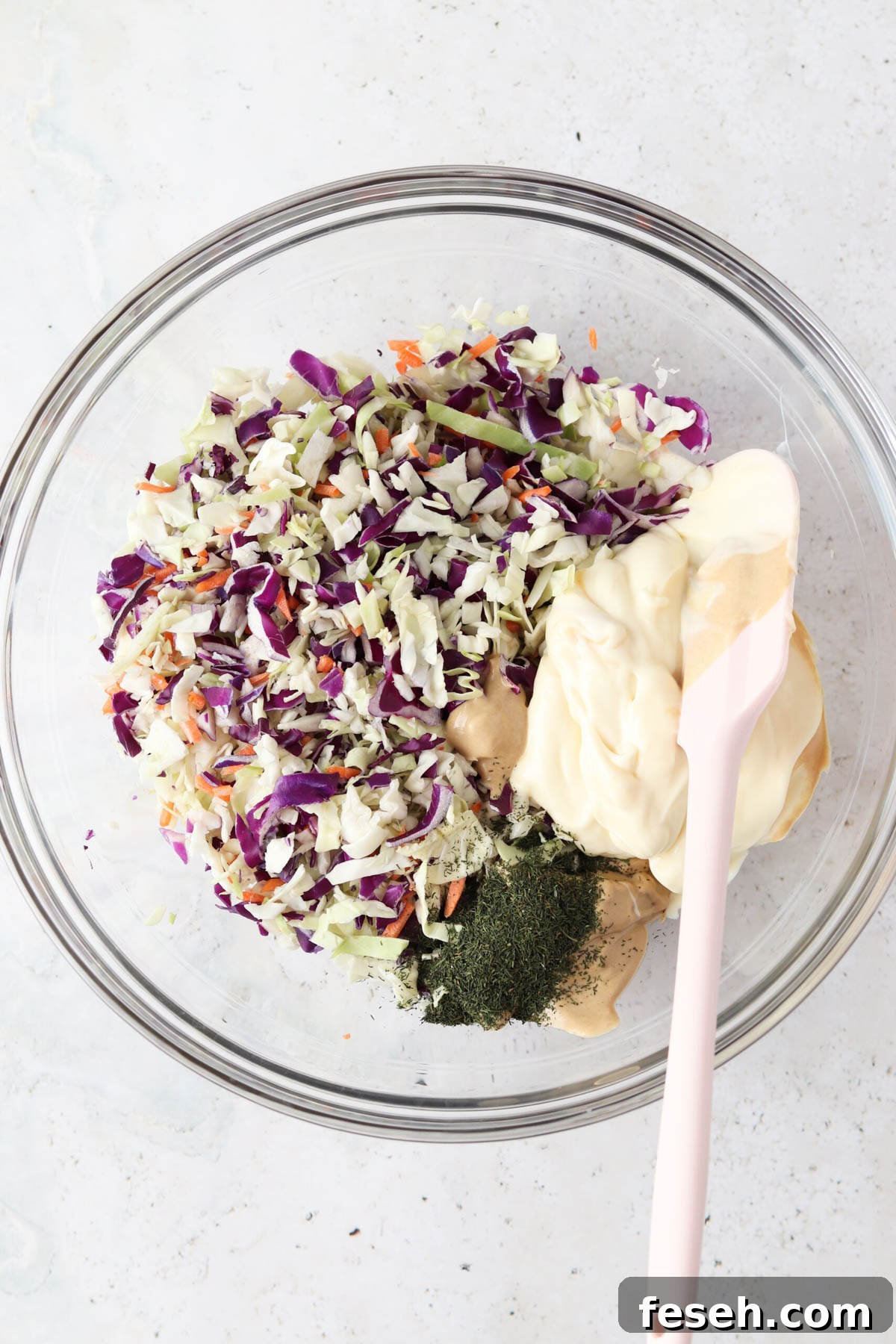 Gluten free coleslaw ingredients in a large glass bowl unmixed.