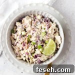 Gluten free coleslaw in a bowl with a gold spoon.