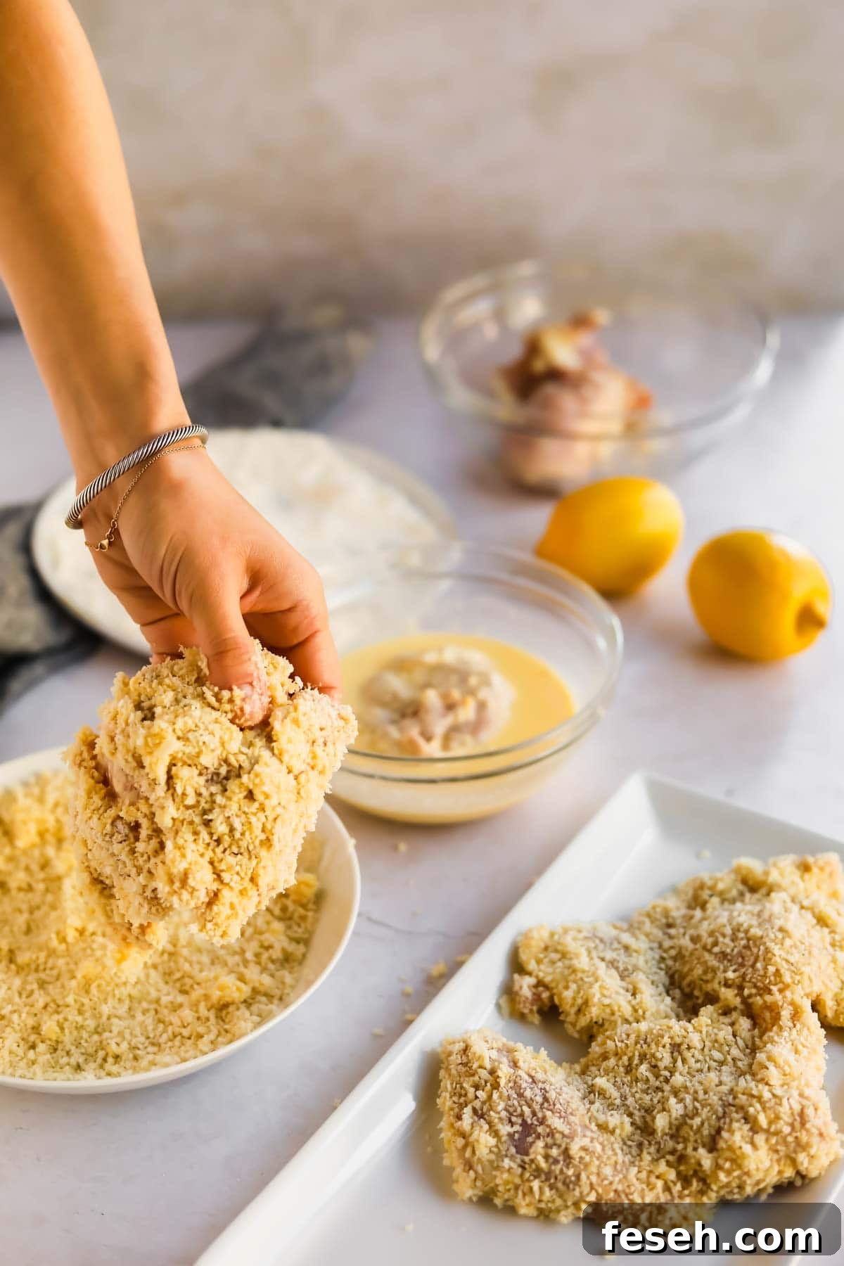 Chicken dipped in batter and panic being placed on plate.