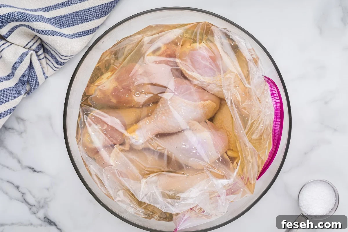 chicken drumsticks in Ziploc bag with brine, all in glass bowl.