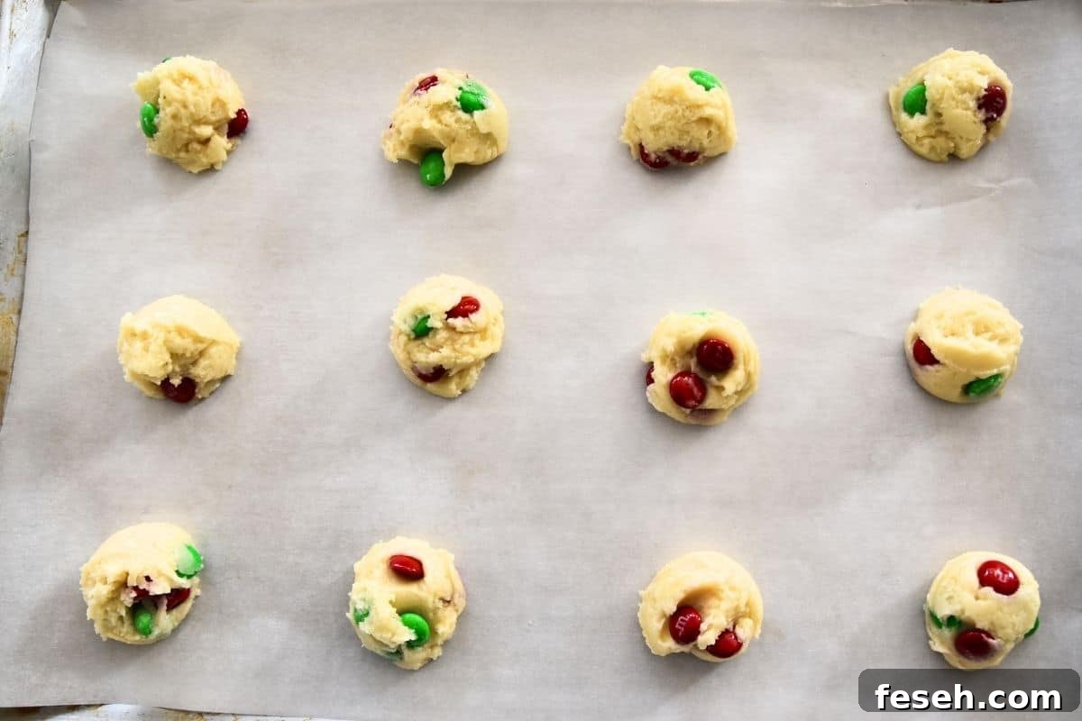 cookie dough with M&MS on cookie sheet.