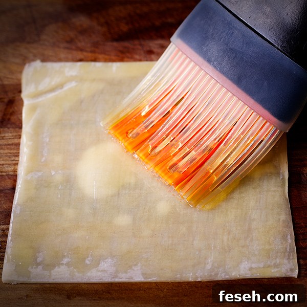 Brushing a wonton wrapper with olive oil.