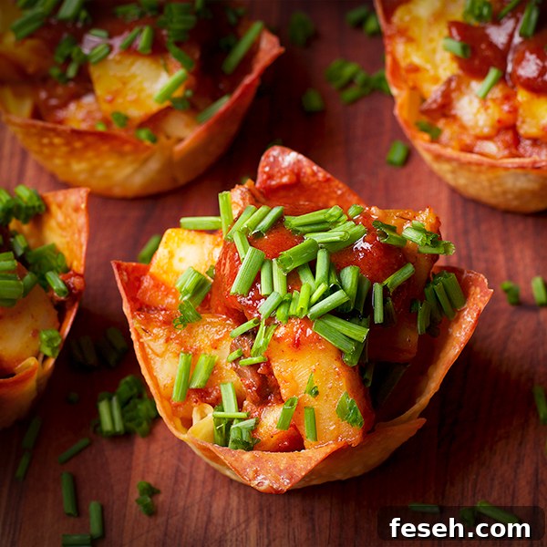 A tray of Roasted Celery Root, Mushroom, and Goat Cheese Wonton Cups with Date BBQ Sauce and Chili Oil.