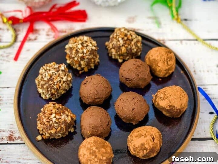 A black plate with twelve round pumpkin chocolate truffles, some coated in nuts and some in cocoa powder, on a festive table with colorful decorations in the background.