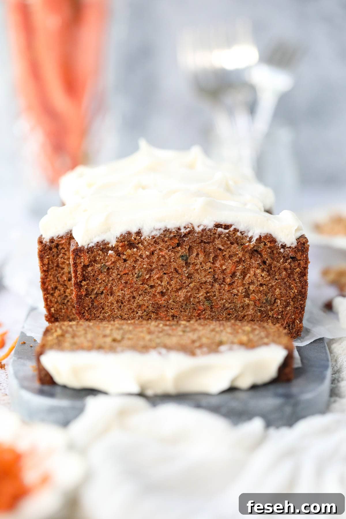 Sliced carrot cake loaf on a marble cutting board.