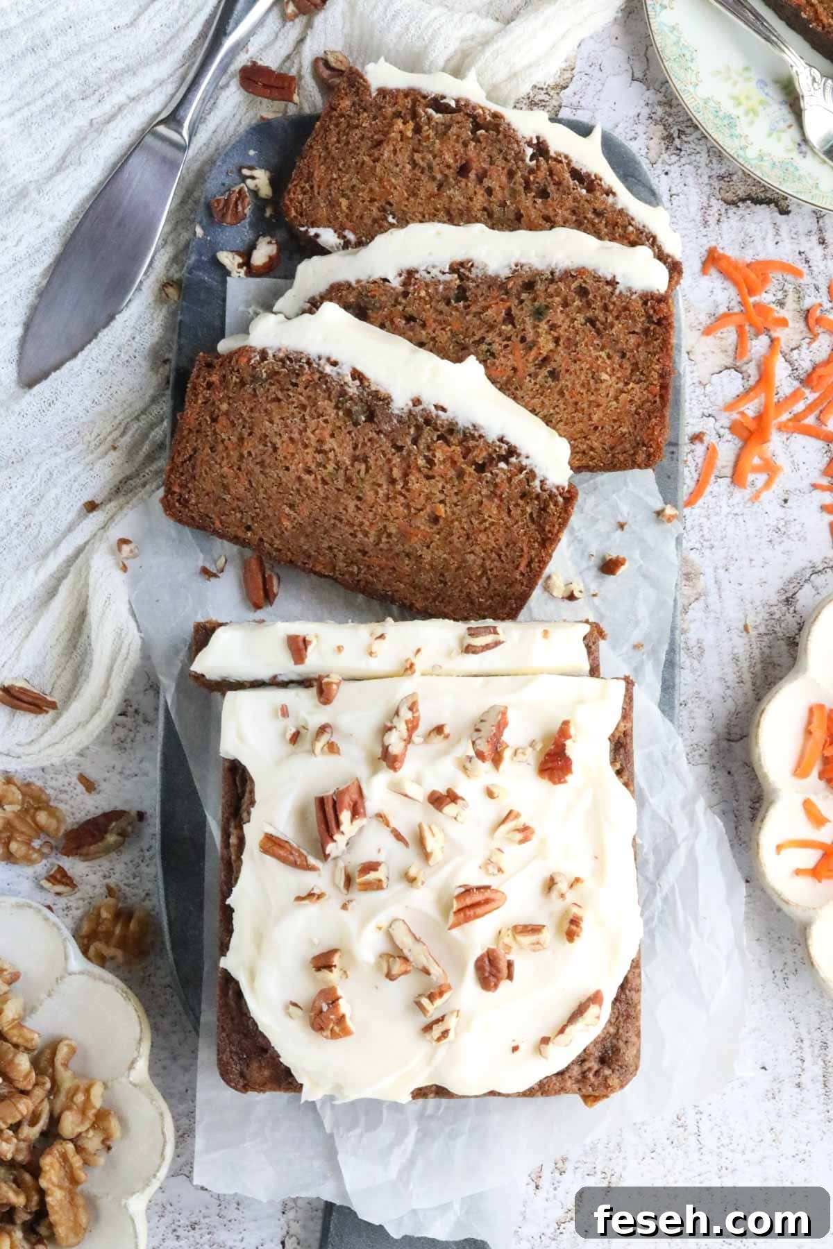 Sliced carrot cake loaf on a white surface.