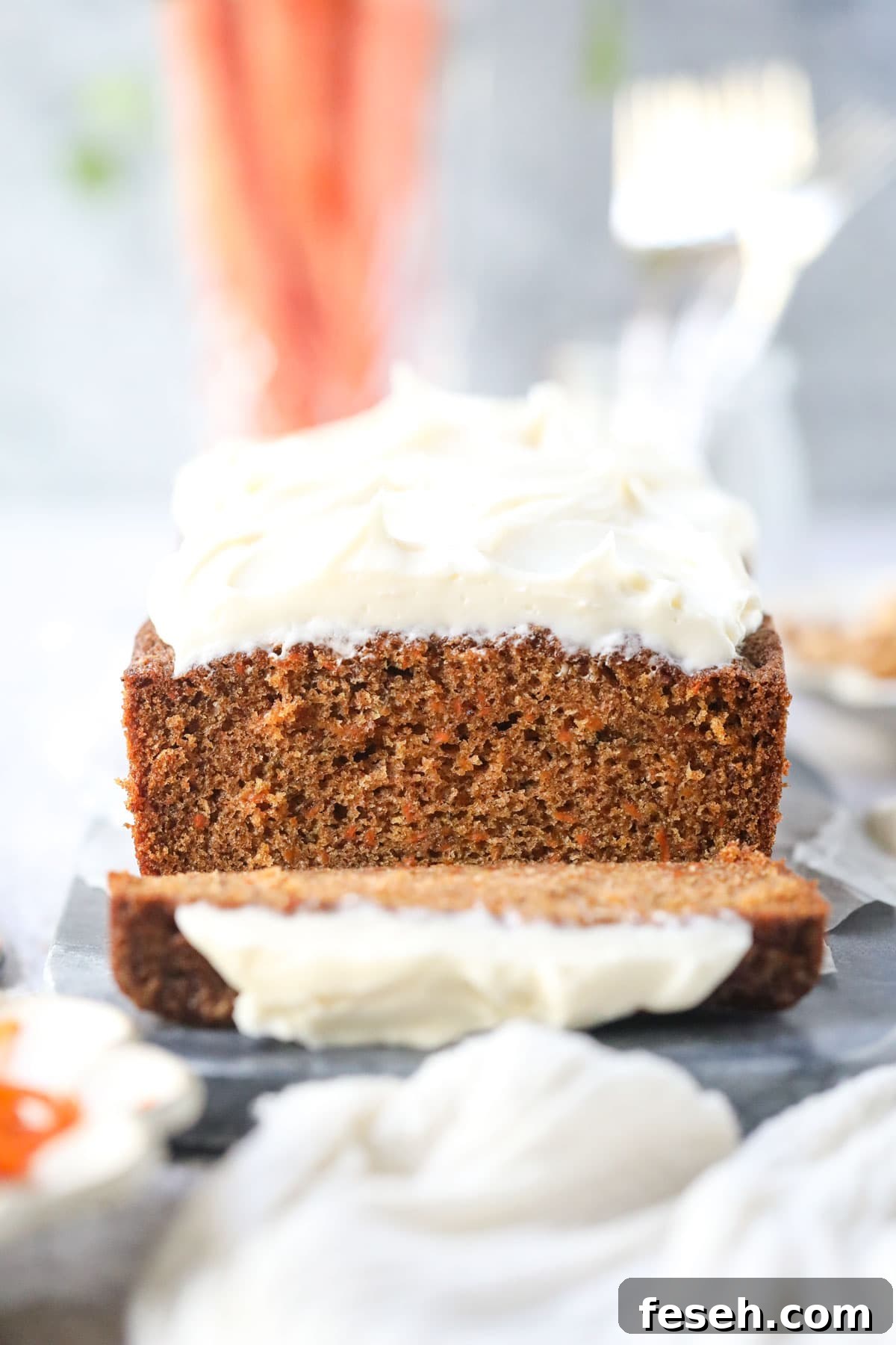 Sliced carrot cake loaf on a white surface.