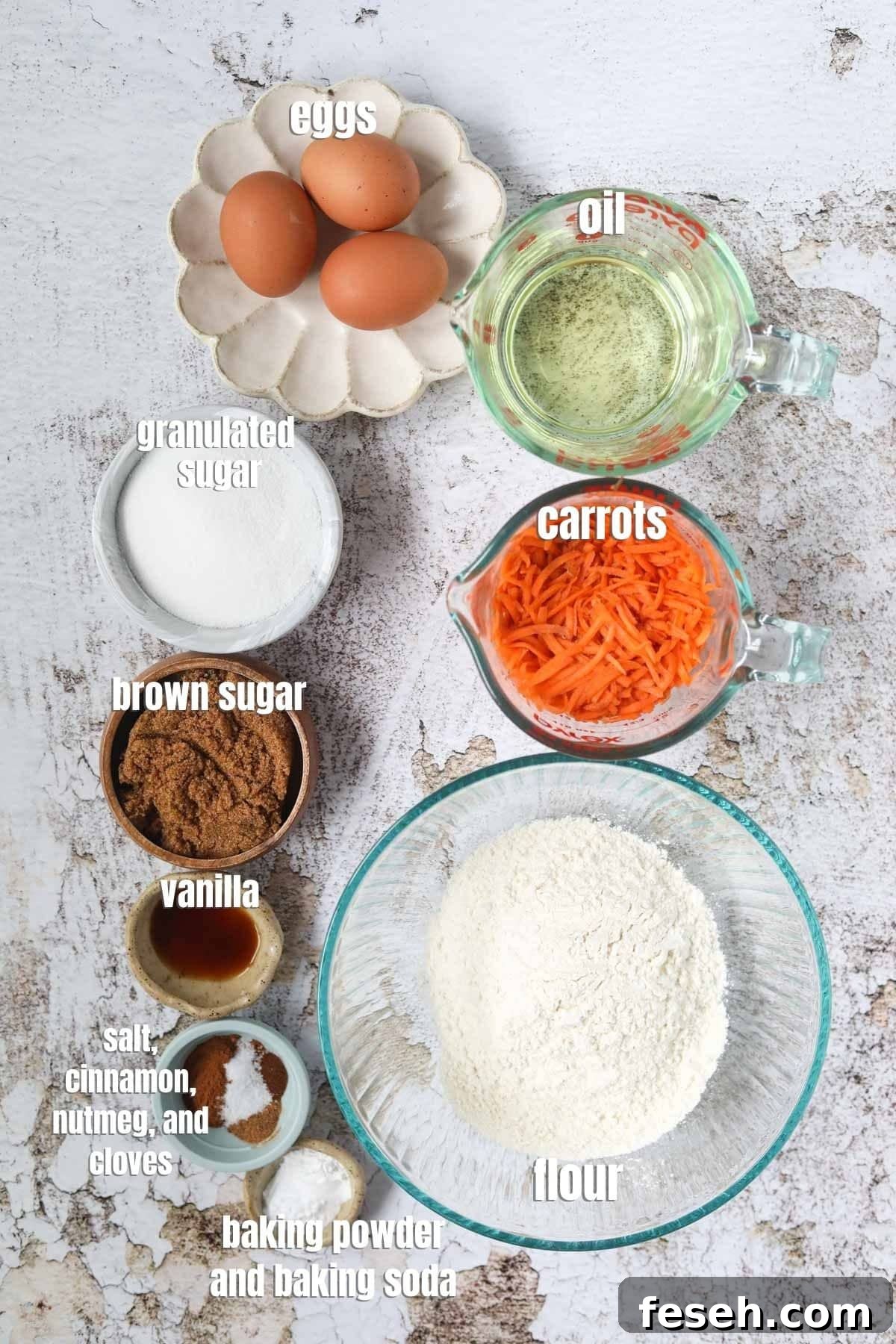 Carrot cake ingredients spread out on a white surface.