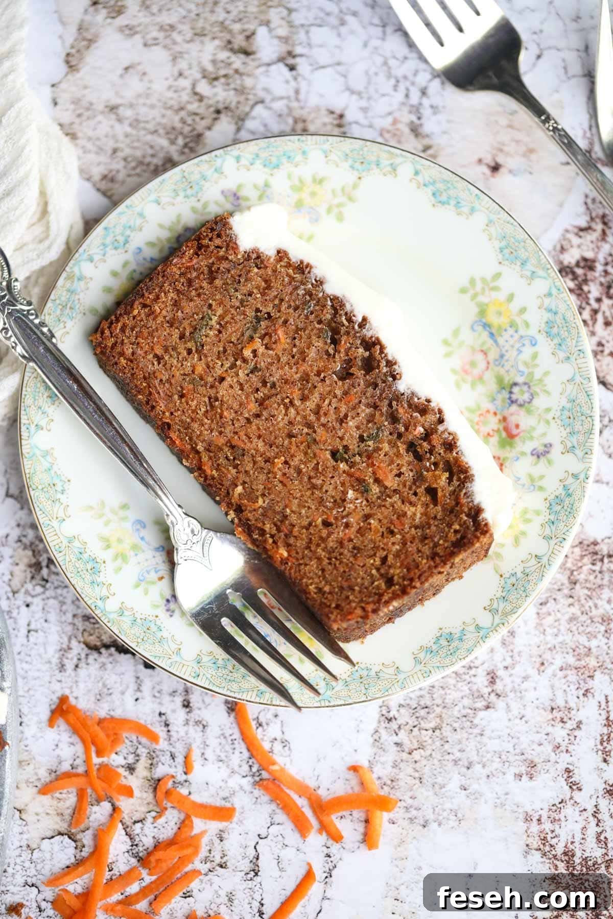 Slice of carrot cake on a white plate.