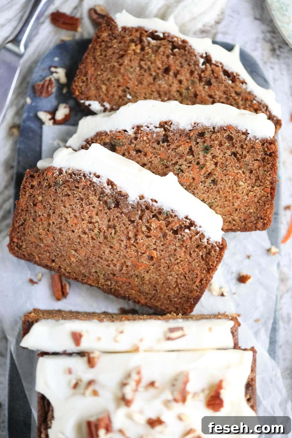 Sliced carrot cake on a marble cutting board.