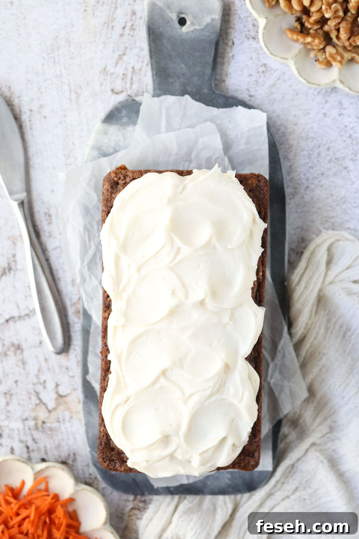 Carrot cake loaf on a marble cutting board.