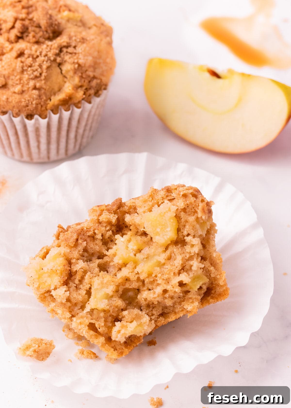 Half of a gf apple muffin, showing the texture of the muffin and the chunks of apple inside.