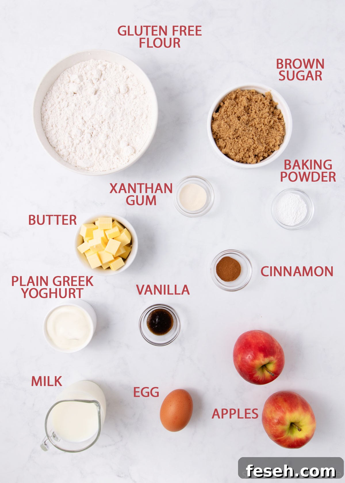 The gluten free apple muffin ingredients in small bowls on a pale grey marble background.