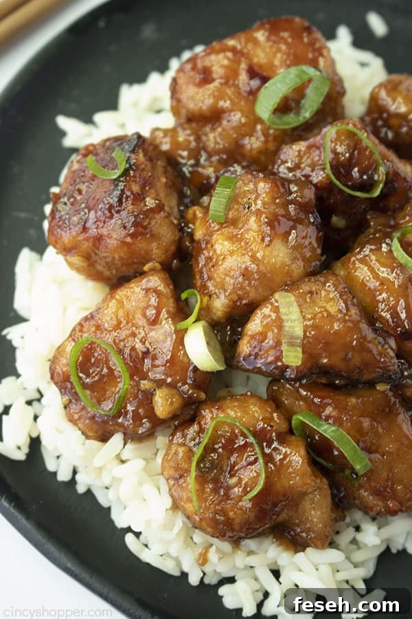 General Tso's Chicken over rice on a black plate.