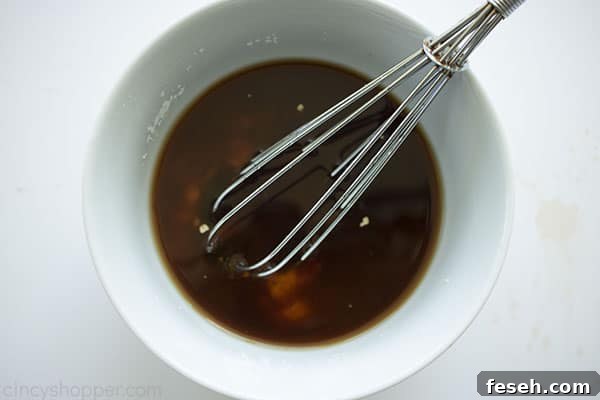 Sauce in a white bowl with whisk