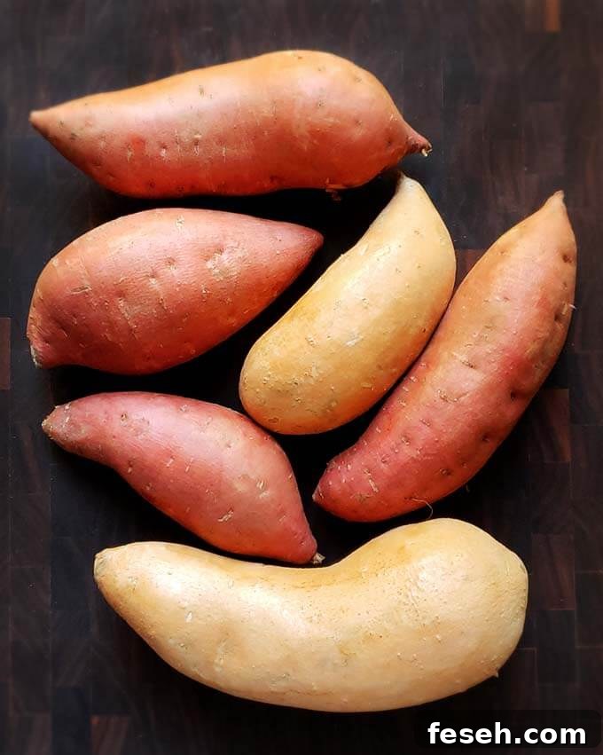 Six uncooked sweet potatoes on a dark wooden surface