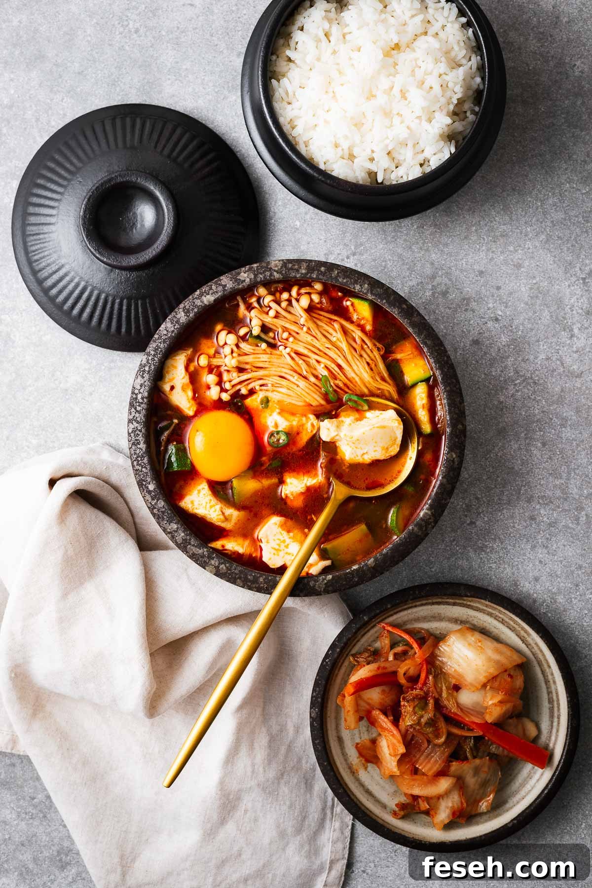 Korean soft tofu stew (sundubu jjigae) served with rice and kimchi.
