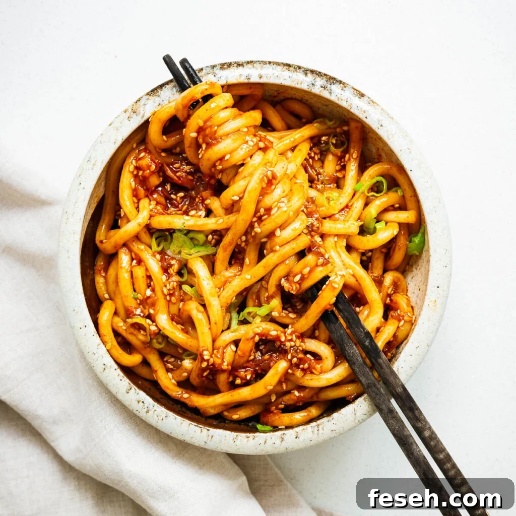 A bowl of udon noodles with a spicy gochujang noodle sauce.