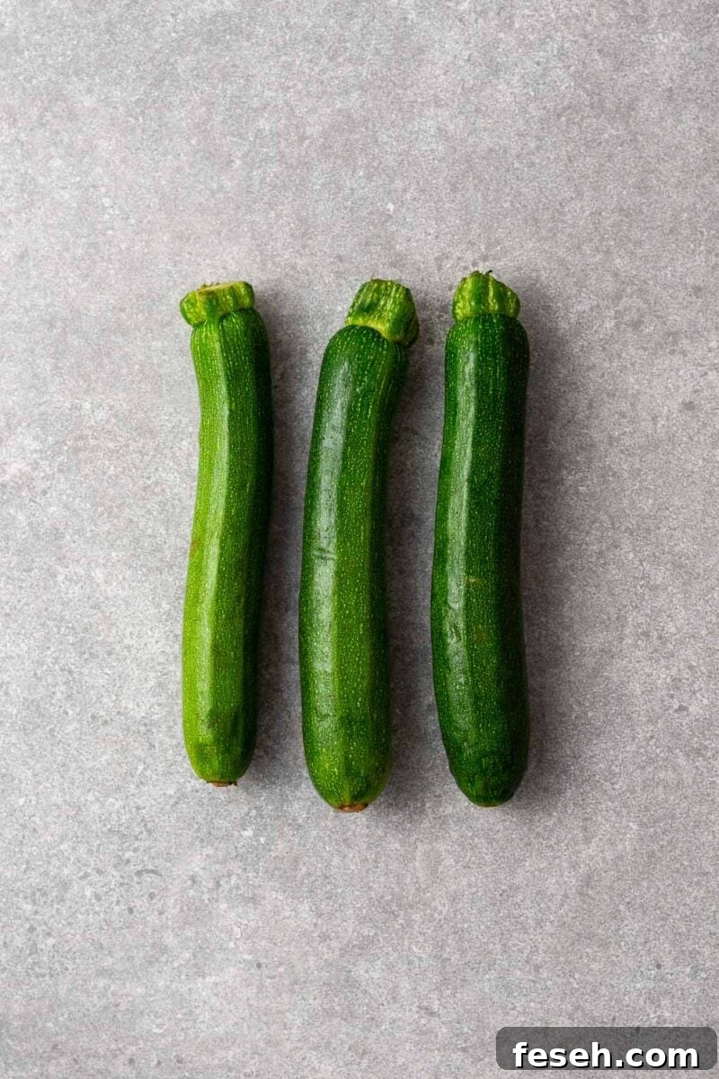 Three baby zucchini, also called baby marrow or baby courgette.
