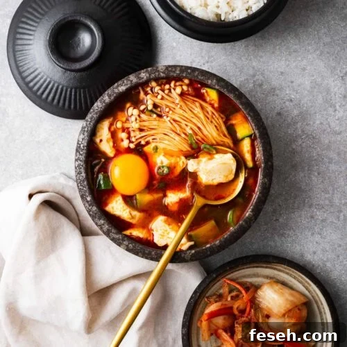 Korean soft tofu stew (sundubu jjigae) served with rice and kimchi.