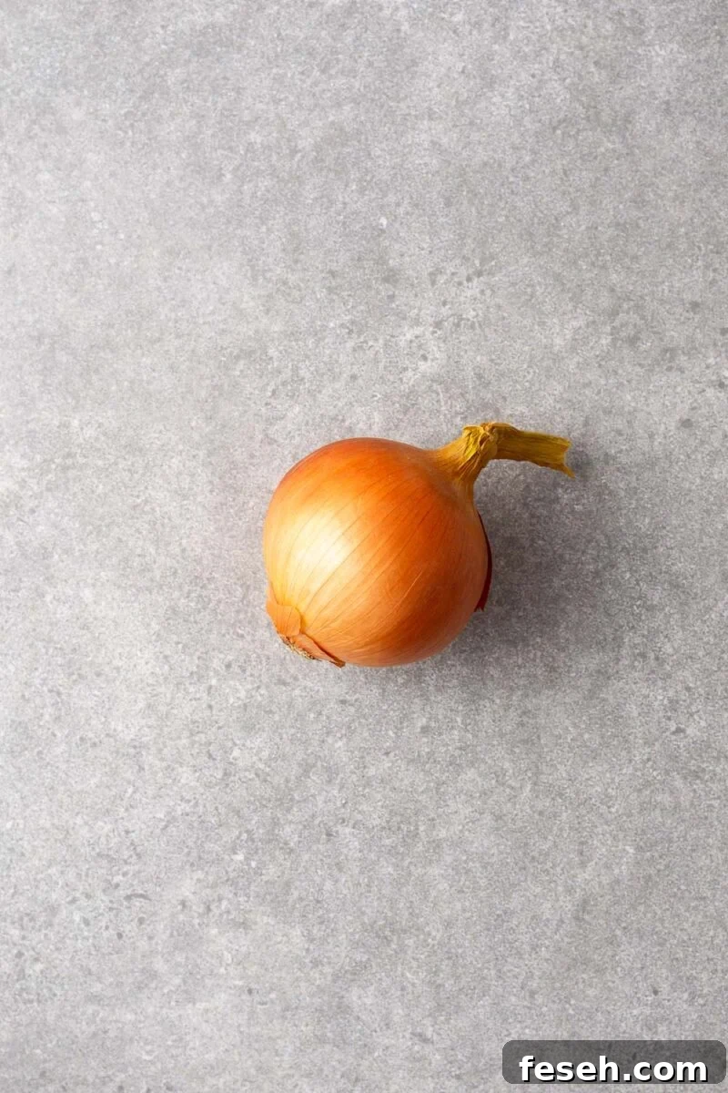 An unpeeled brown onion.