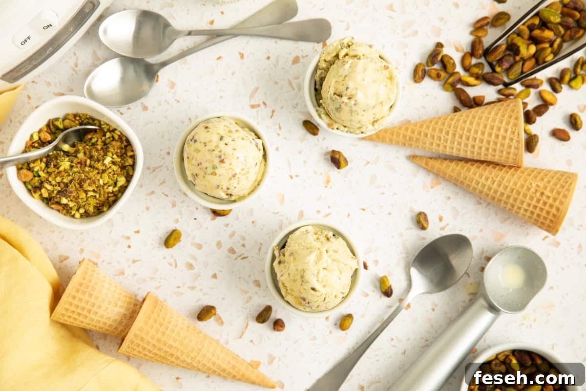 Cups of pistachio ice cream with cones and pistachio pieces laying around