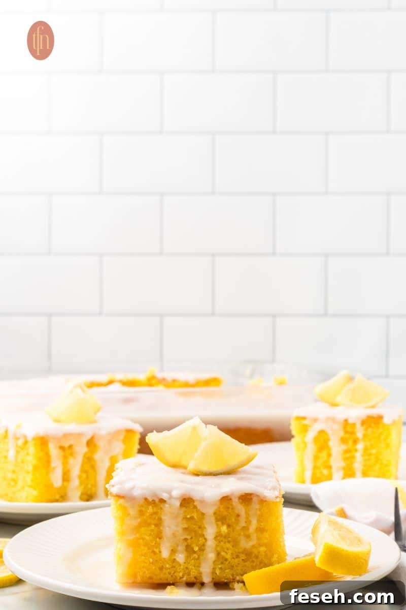 Three slices of cake with white glaze and slice of lemon on top.