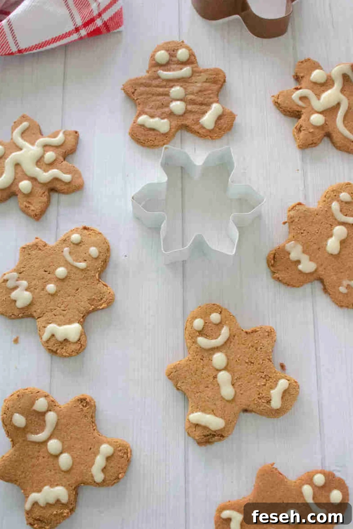 High protein gingerbread cookies with frosting and a cookie cutter in the middle.