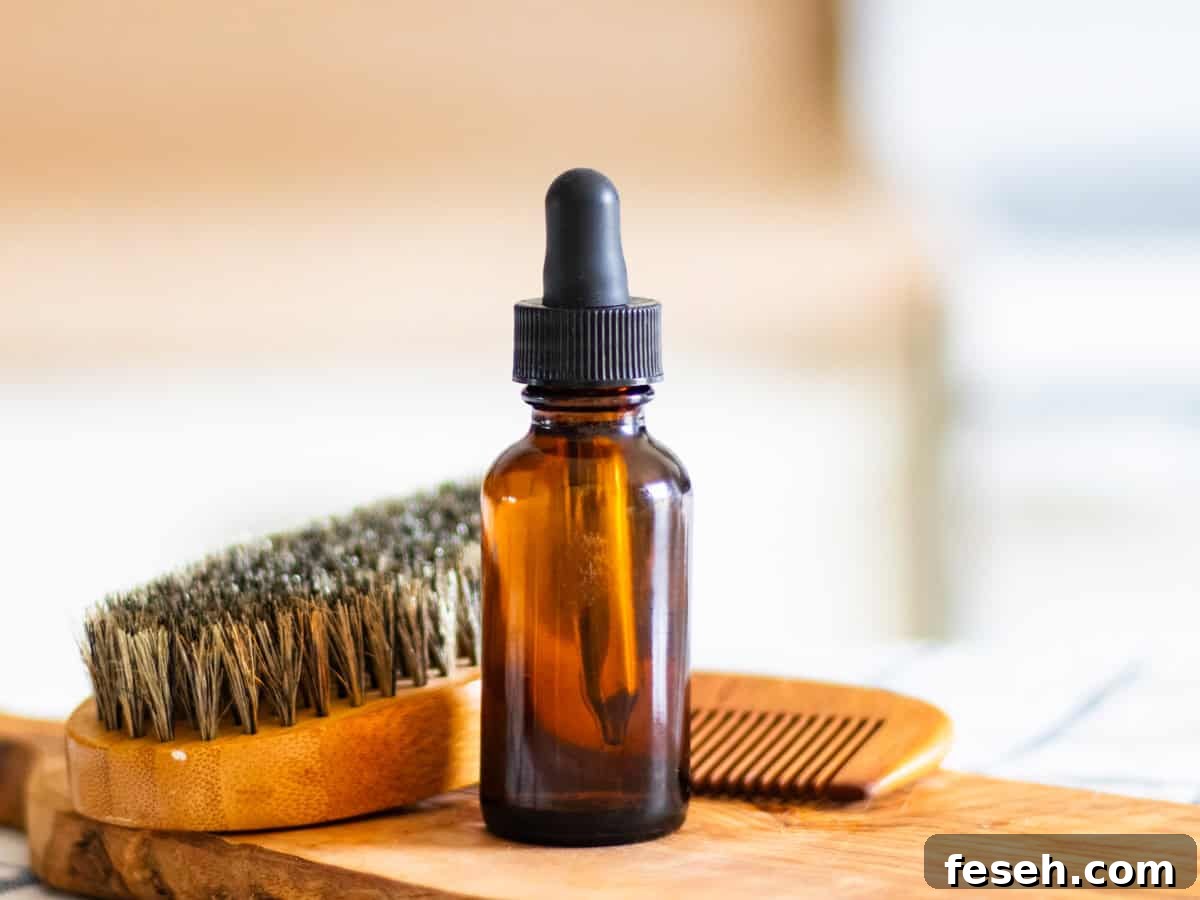 A bottle of homemade beard oil with a beard brush on a wooden board.