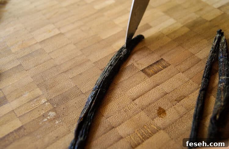Vanilla bean with a knife slicing down the middle